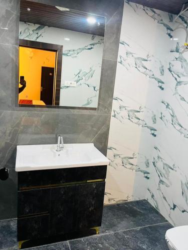 a bathroom with a sink and a mirror at Hotel Manglam in Kota
