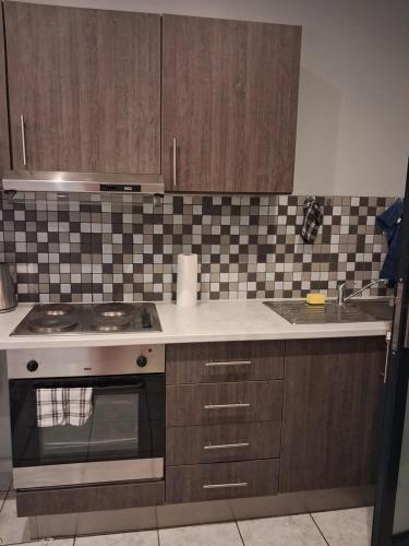 een keuken met een fornuis en een spoelbak bij TripleM comfort zone in Windhoek