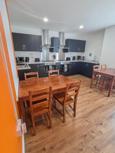 a large kitchen with a wooden table and chairs at Hullywood rooms with shared kitchen facilities in Hull