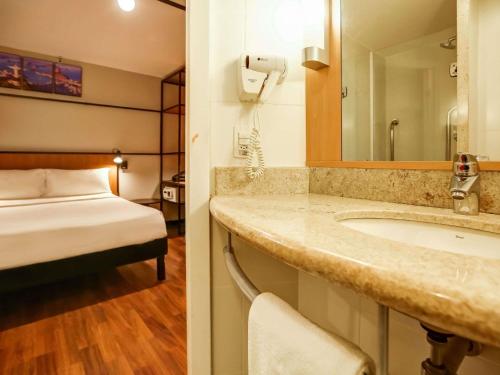 ein Badezimmer mit Waschbecken und ein Bett in einem Zimmer in der Unterkunft ibis Copacabana Posto 2 in Rio de Janeiro