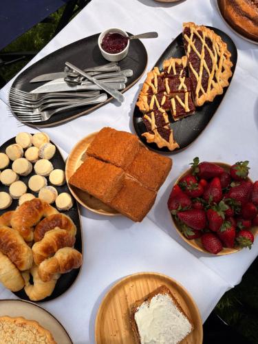 皮纳马尔Black Suites Pinamar的一张白色的桌子,上面放着食物和糕点