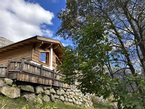 a log cabin on a hill with a stone wall at Chalet am Bachl 1 in Flattach