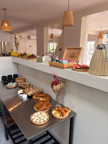 a table with different types of bread and pastries on it at Black Suites Pinamar in Pinamar