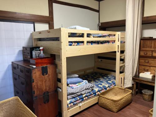 Litera de madera en habitación con escritorio en はやちねの宿ラビット, en Hanamaki