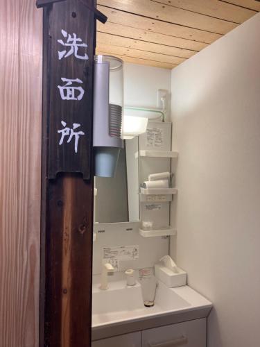 un baño con lavabo y espejo en はやちねの宿ラビット, en Hanamaki