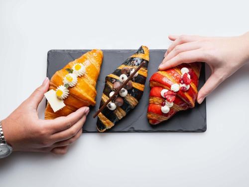 金边金边索菲特佛基拉酒店 的一盘寿司，两只手拿着。