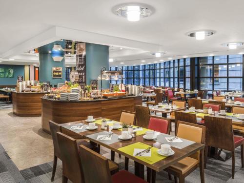 a dining room with tables and chairs and a restaurant at Mercure Budapest City Center in Budapest