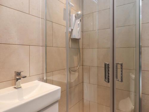 a shower with a glass door next to a sink at Heath Hideaway in Sowerby Bridge