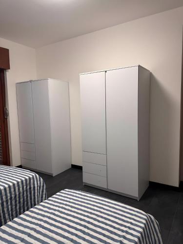 two white cabinets in a room with two beds at Casa Aris in Staranzano