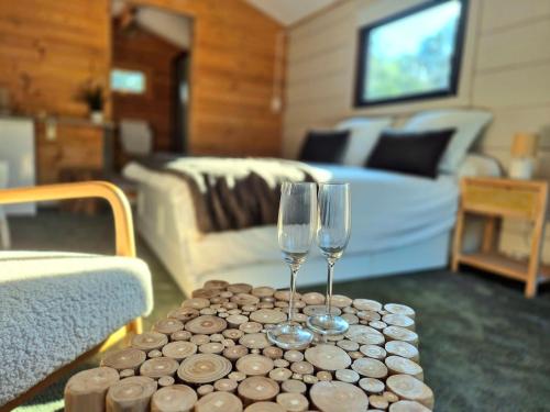 two wine glasses on a table in a living room at Suite privée indépendante en bois- Sud Ardèche in Saint-Paul-le-Jeune