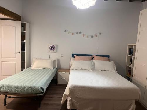 a bedroom with two beds and a chandelier at La casita de horno in Toledo