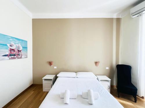 una camera da letto con un letto bianco e un quadro sul muro di La Casa di Benny e Mary al Vaticano a Roma