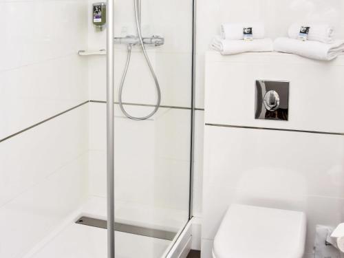 un bagno bianco con doccia e WC di Mercure Granville Le Grand Large a Granville