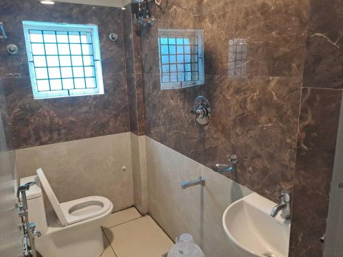 a bathroom with a toilet and a tub and a sink at Hotel O Sri Sakthi Mahal in Chennai