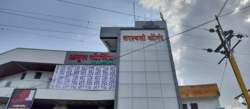 a building with a sign on the side of it at Hotel O Amrut Lodge in Sāsvad