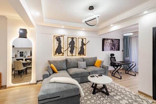 a living room with a couch and a table at Westlands Oasis, Luxury Pool, Gym & Gaming Fun in Nairobi