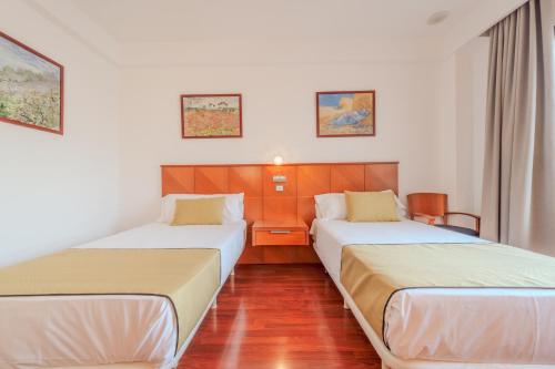 two beds in a hotel room next to each other at Hotel ITC Ciudad de Haro in Haro