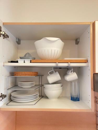 a kitchen cabinet with plates and bowls and dishes at Gemütliches Apartment in zentraler Lage in Ingolstadt