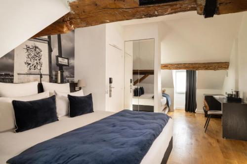 パリにあるMidnight Hôtel Parisの大きなベッドと机のある寝室