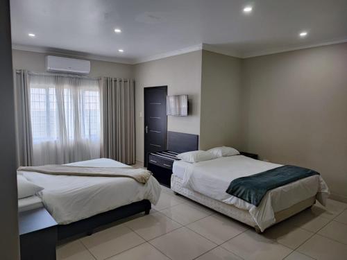 a bedroom with two beds and a window at 33onBazley Hotel in Durban