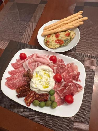 Dos platos de comida con carne y huevos en una mesa. en Eisenau Luxury View, en Prisaca Dornei