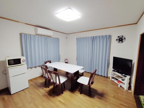 a dining room with a table and chairs and a television at Seaside Villa Matsugaya - Vacation STAY 19447 in Sammu