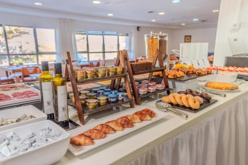 Un buffet con muchos tipos diferentes de comida en una mesa. en Hotel ITC Ciudad de Haro, en Haro
