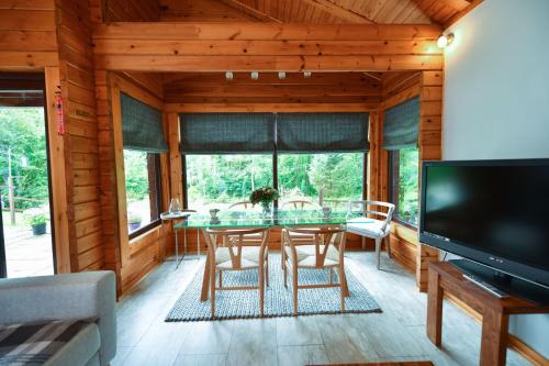 a dining room with a table and chairs and a television at Lyall Lodge in East Barcloy