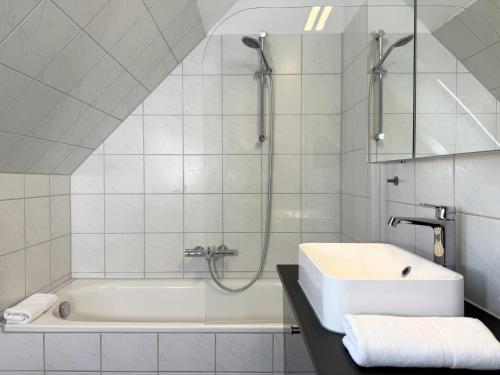un bagno con lavandino e vasca da bagno di Blankwasser 11 a Grömnitzerhagen