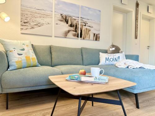 a living room with a blue couch and a coffee table at Küste33-22 Lotta in Tossenserdeich