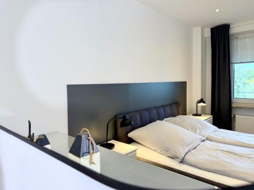 a bedroom with a bed and a table and a mirror at Blankwasser 169 in Grömnitzerhagen