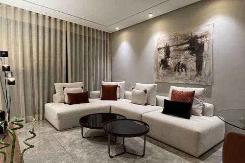 Una sala de estar con dos sofás blancos y una mesa. en The Address to Ocean - By AppartAli, en Anfa-Supérieur