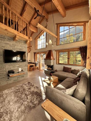 a living room with a couch and a fireplace at Chalet am Bachl 2 in Flattach