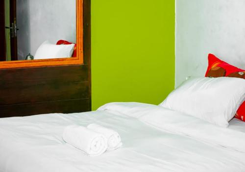Una cama con dos toallas y un espejo. en Guest House Bobonito, en Beira