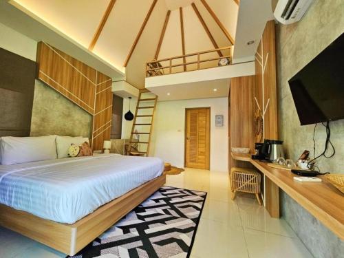 a bedroom with a bed and a desk and a television at Siri Lagoona Resort in Nong Prue
