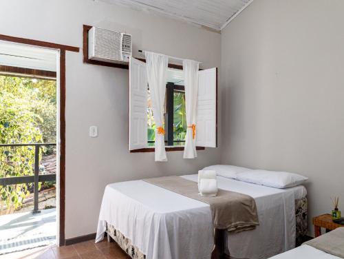 a bedroom with two beds and a window at Recanto D'Ajuda in Arraial d'Ajuda