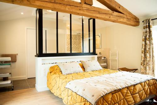 a bedroom with a large bed with a large window at Le mas de l'ecluse in Caux-et-Sauzens