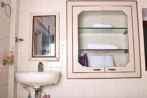 une salle de bain avec un lavabo et un miroir dans l'établissement Heritage Stay in Johari Bazaar, à Jaipur