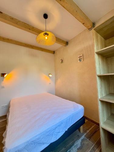 1 dormitorio con 1 cama en una habitación con estanterías en Appartement Cosy avec balcon, en Arles