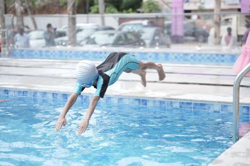 a young boy diving into a swimming pool at Oceanus Retreat in Kottiyam