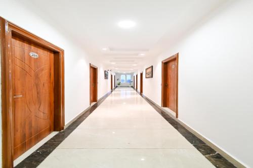 an empty corridor in a building with wooden doors at Collection O Royal King in Rohtak