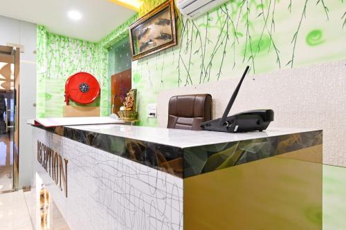 a reception desk with a laptop on top of it at Collection O Royal King in Rohtak