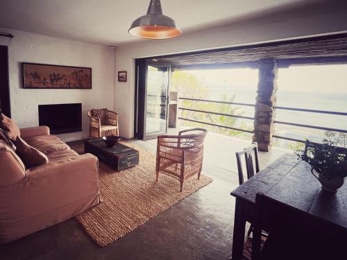 a living room with a couch and a table at Die Ou Kliphuis in Plettenberg Bay