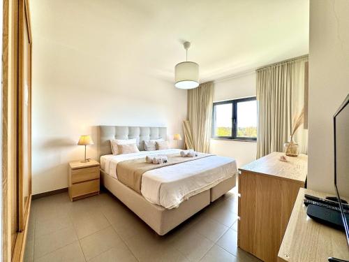 a bedroom with a large bed and a television at Pêra Secret Garden 2 With Pool by Homing in Pêra