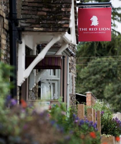 a red lion sign on the side of a house at The Red Lion Hotel in Cambridge