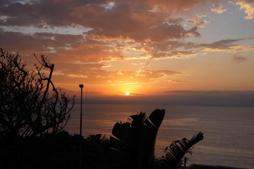 a sunset over the ocean with the sun in the sky at Die Ou Kliphuis in Plettenberg Bay