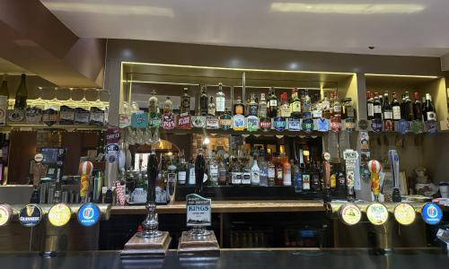 a bar filled with lots of bottles of alcohol at The Red Lion Hotel in Cambridge
