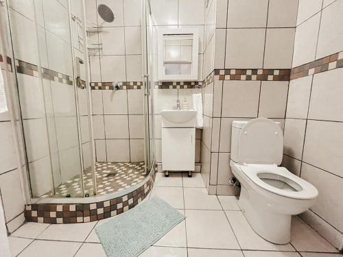 un baño con inodoro y ducha en Cozy one bed, just a short walk to the beach, en Strand