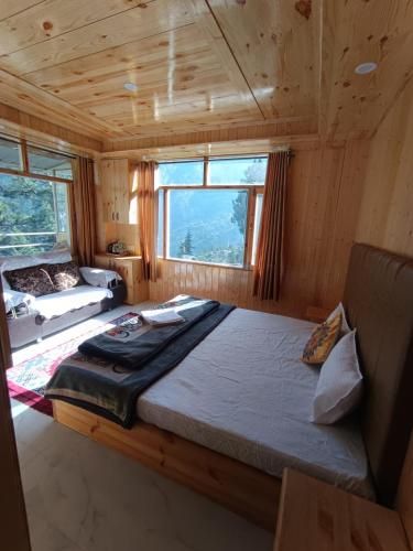 a large bed in a wooden room with a window at The Shudarang Inn in Kalpa