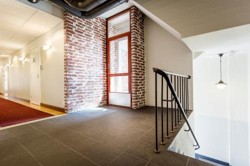 an empty hallway with a brick wall and a window at Hotelli Ville in Tampere
